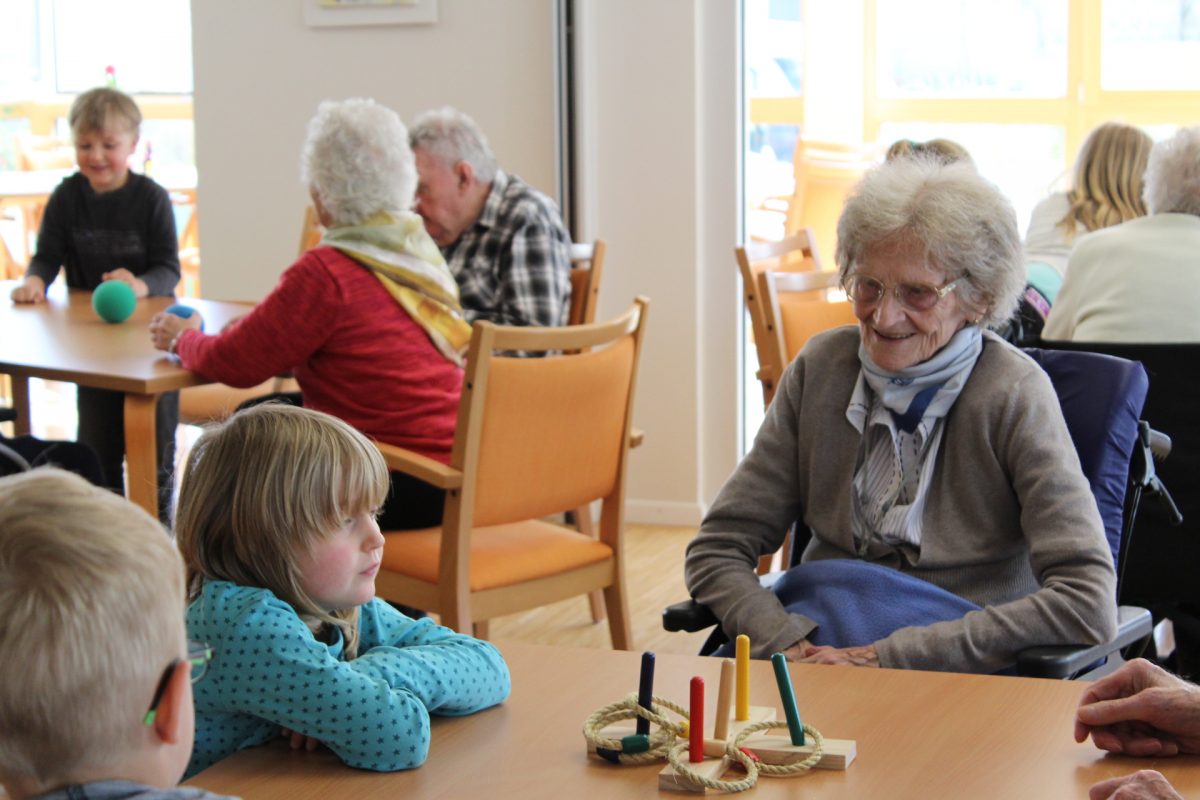 Kinder und Senioren spielen zusammen